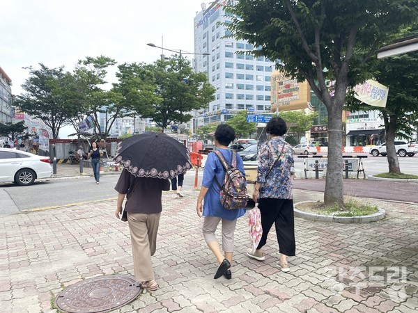 20일 무더운 날씨에 양산을 들고 걷고 있는 노인들.